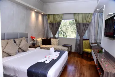 a hotel room with a bed with towels on it at Sinclairs Retreat Ooty in Ooty