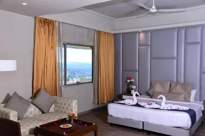a bedroom with a bed and a couch and a window at Sinclairs Retreat Ooty in Ooty