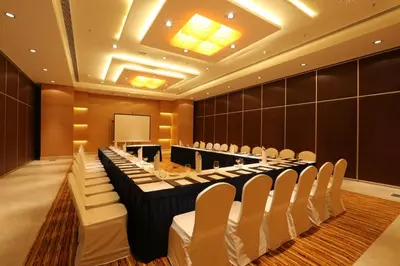 a conference room with rows of tables and chairs at Mysore County Retreat in Mysore