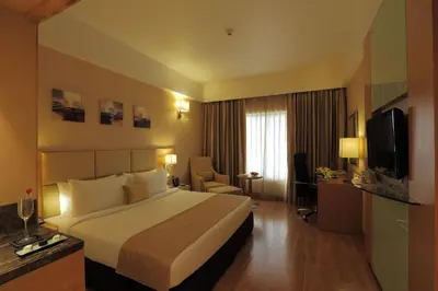 a hotel room with a bed and a television at Mysore County Retreat in Mysore