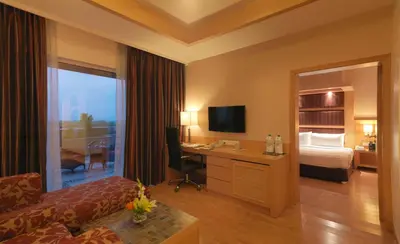 a hotel room with a bed and a desk with a computer at Mysore County Retreat in Mysore