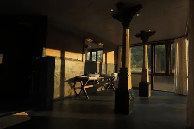 a dark room with a table and a lamp at SpiceTree Chinnar in Dhali