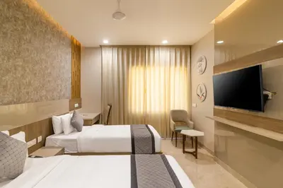 a hotel room with two beds and a flat screen tv at Rathna Residency in Erode