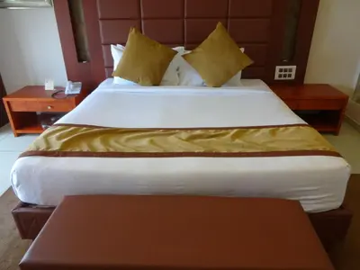 a large bed in a hotel room with a table at Paramount Tower in Kozhikode