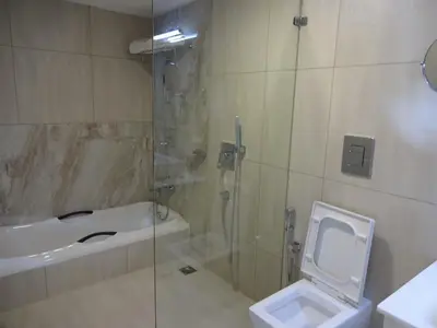a bathroom with a shower and a toilet and a sink at Paramount Tower in Kozhikode