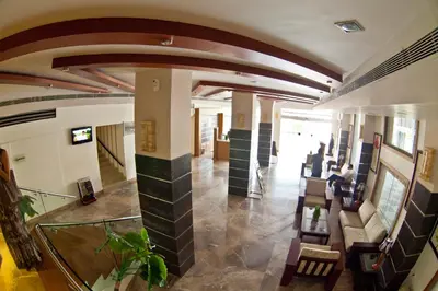 a lobby of a building with a person sitting on a couch at Paramount Tower in Kozhikode