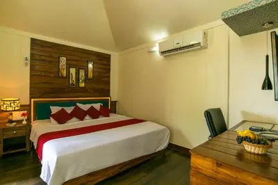 a bedroom with a large bed and a desk and a bed sidx sidx sidx at Olives The Boutique Resort in Kalpetta