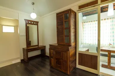 a bathroom with a large wooden cabinet and a mirror at Olives The Boutique Resort in Kalpetta