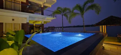 a swimming pool in front of a house at night at SAGAR BEACH VILLAS Home stay in Cherai Beach