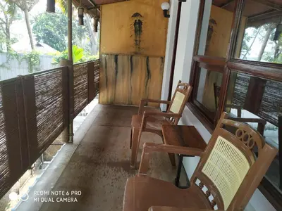 a porch of a house with chairs and windows at SAGAR BEACH VILLAS Home stay in Cherai Beach
