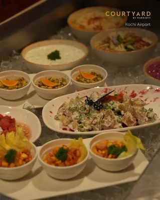 a bunch of bowls of food on a table at Courtyard by Marriott Kochi Airport in Nedumbassery