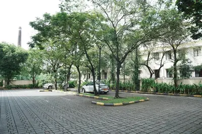 a parking lot with trees and cars on a street at Courtyard by Marriott Kochi Airport in Nedumbassery