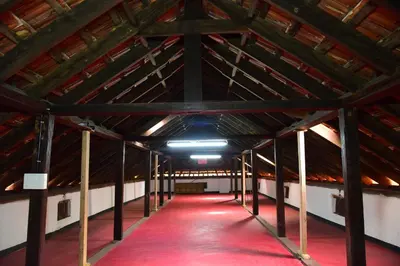 a large room with a red carpet in a wooden ceiling at Keloth Tharavadu in Panamaram