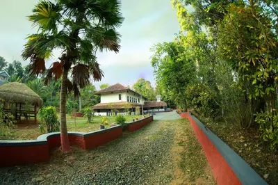 a pathway leading to a resort with a water slide at Keloth Tharavadu in Panamaram