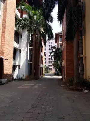 an empty street with palm trees and buildings at Vrindavan Suites Guruvayur in Guruvāyūr