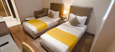two beds in a hotel room with at The Mayberry -A Bergamont Group of Hotels in Tiruppūr