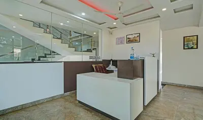an office with a white counter and a staircase at Itsy Hotels Vijaya Comforts, With Bar & Restaurant in Madikeri