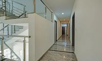 a staircase in a house with glass railings at Itsy Hotels Vijaya Comforts, With Bar & Restaurant in Madikeri
