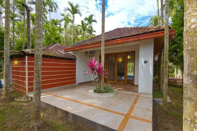 a small house with a patio in front of it at StayVista at Tall Silver with Infinity Pool & Breakfast -2BR in Madikeri