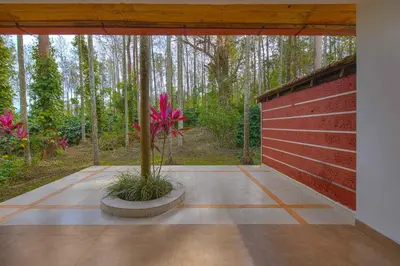 a patio with a red fence and a plant at StayVista at Tall Silver with Infinity Pool & Breakfast -2BR in Madikeri