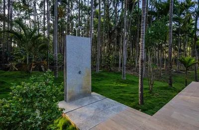 a monument in the middle of a forest of trees at StayVista at Tall Silver with Infinity Pool & Breakfast -2BR in Madikeri