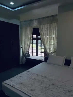 a bedroom with a large bed and a window at Maleyam Homestay Riverside in Kozhikode