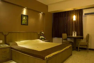 a bedroom with a large bed and a christmas tree at Comfort Hotels in Coimbatore