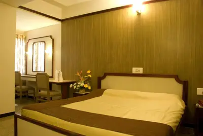 a bedroom with a bed and a desk and a table at Comfort Hotels in Coimbatore