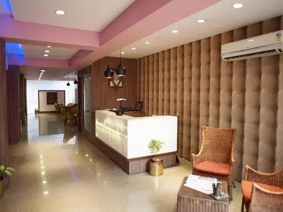 a lobby with a large wall with a sink and chairs at Comfort Hotels in Coimbatore