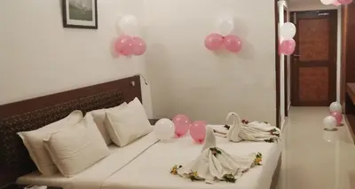 a bedroom with a bed with pink and white balloons at French Avenue in Kallāyi