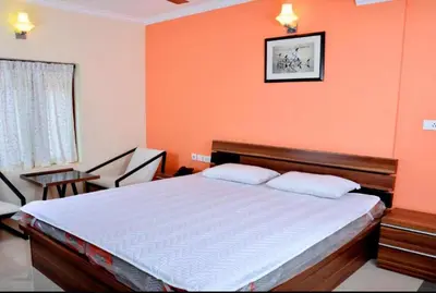 a bedroom with orange walls and a bed with two pillows at French Avenue in Kallāyi