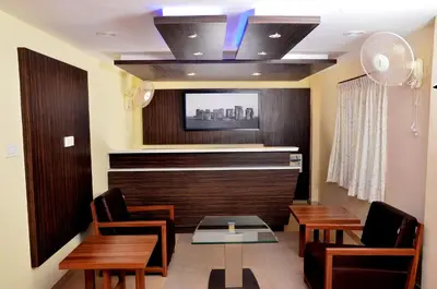 a waiting room with a table and chairs and a tv at French Avenue in Kallāyi