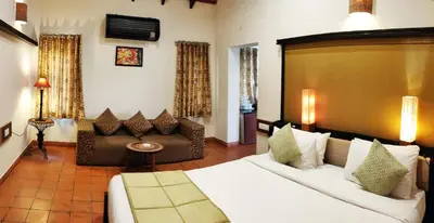 a hotel room with a bed and a couch at Kadkani River Resort Coorg in Siddapur