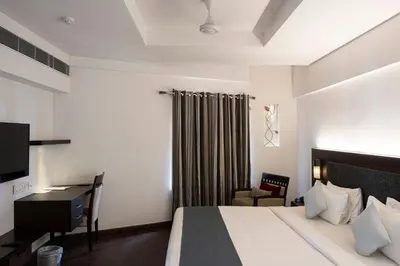 a bedroom with a bed and a desk and a chair at Copper Folia in Kozhikode
