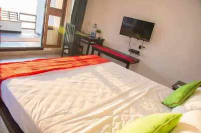 a bedroom with a bed and a tv and a table at 36 Palms Residency - Sea View Villa in Cochin