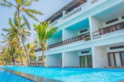a hotel with a swimming pool in front of a building at 36 Palms Residency - Sea View Villa in Cochin