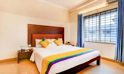 a bedroom with a large bed with a colorful blanket at Itsy Hotels Ammu Regency in Trichūr