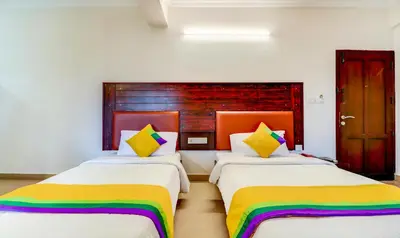 two beds in a room with colorful sheets at Itsy Hotels Ammu Regency in Trichūr