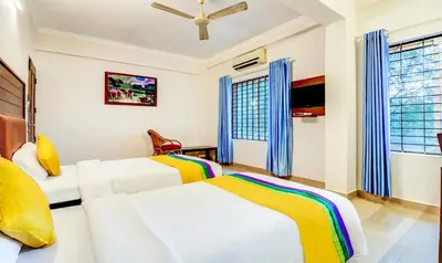 two beds in a room with two windows at Itsy Hotels Ammu Regency in Trichūr