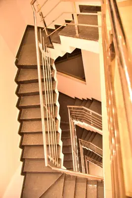 a spiral staircase in a building with metal railings at Le Oak Inn in Mysore