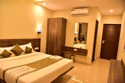 a hotel room with a bed and a mirror at Le Oak Inn in Mysore