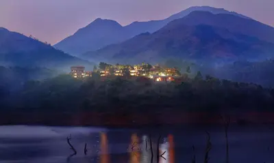 a house on a hill with mountains in the background at CONTOUR ISLAND RESORT & SPA , wayanad in Tariyod