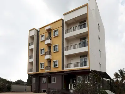 an apartment building with balconies on it at Super Hotel O Indra Comforts in Belagula