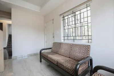 a living room with a couch and a window at Super Hotel O Indra Comforts in Belagula