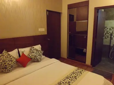 a bedroom with a large bed with pillows on it at The Majestic Crown in Ooty
