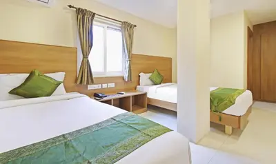 a hotel room with two beds and a window at Itsy Hotels Jansi Residency in Coimbatore