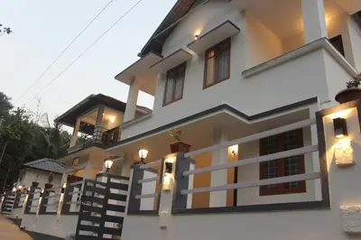 a house with lights on the side of it at Zavon Holiday Home in Vythiri