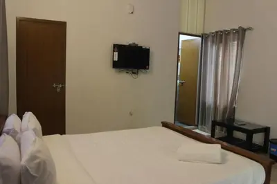 a bedroom with a bed and a tv on the wall at Zavon Holiday Home in Vythiri