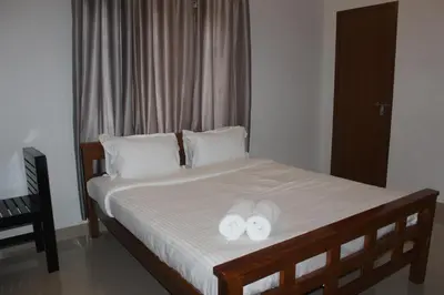 a bed with two white towels on top of it at Zavon Holiday Home in Vythiri