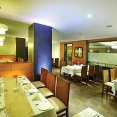 a dining room with tables and chairs in a restaurant at Jk Park Residency Perambra in Mennānyam